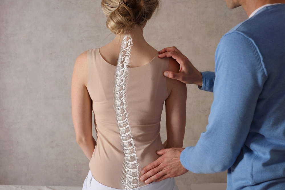 Fisioterapeuta a tratar escoliose nas costas de uma mulher